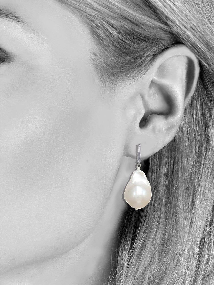 A side view of a woman's face displaying Margo Morrison Fifth Avenue White Baroque Pearl Earrings.