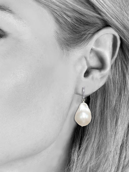 A side view of a woman's face displaying Margo Morrison Fifth Avenue White Baroque Pearl Earrings.