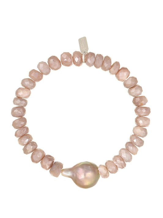 A Margo Morrison Peach Coated Moonstone Stretch Bracelet with irregular peach stones and a single large pearl centerpiece on a white background.