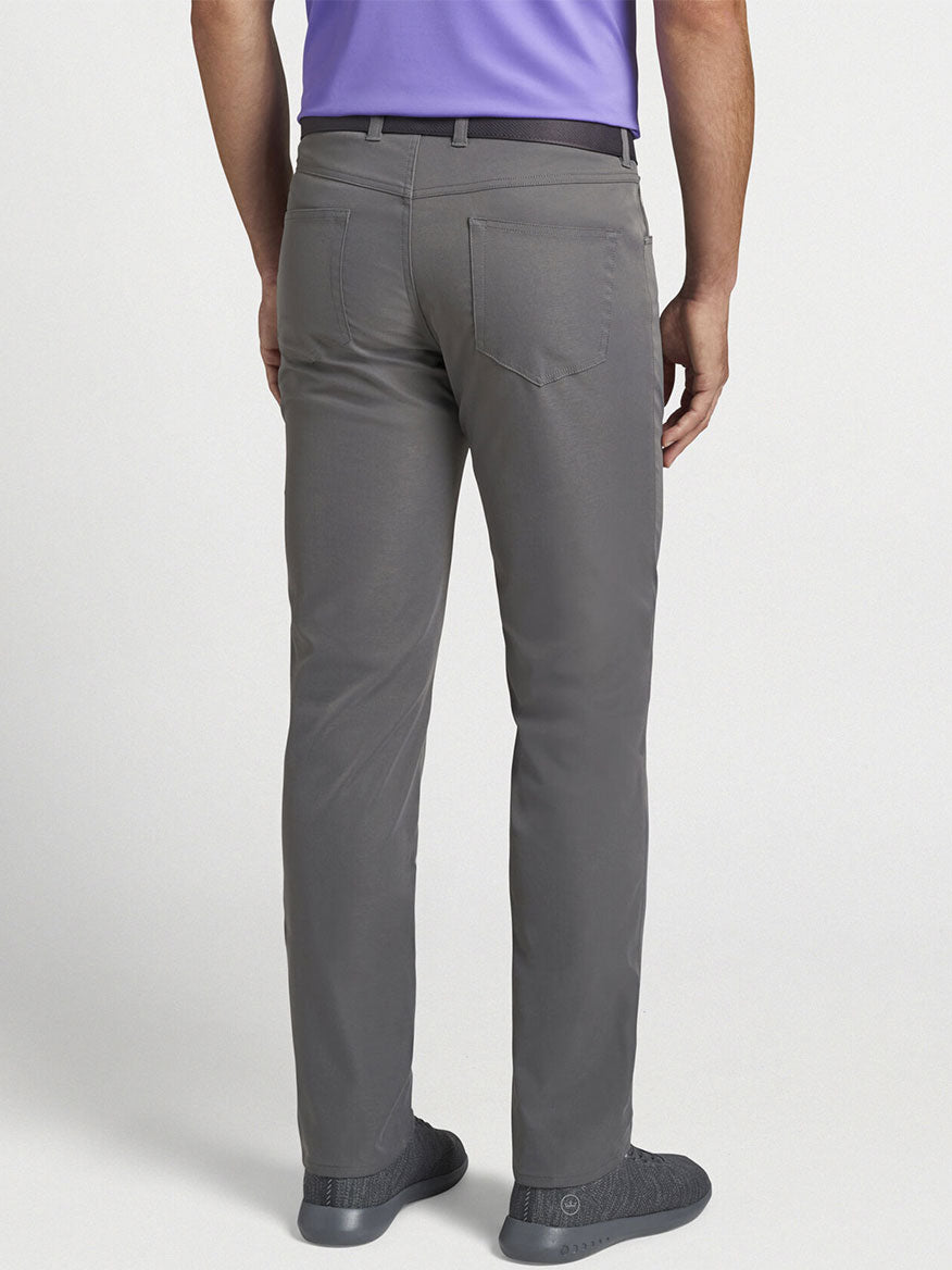 The back view of a man wearing a purple shirt and Peter Millar Performance Five-Pocket Pant in Iron.