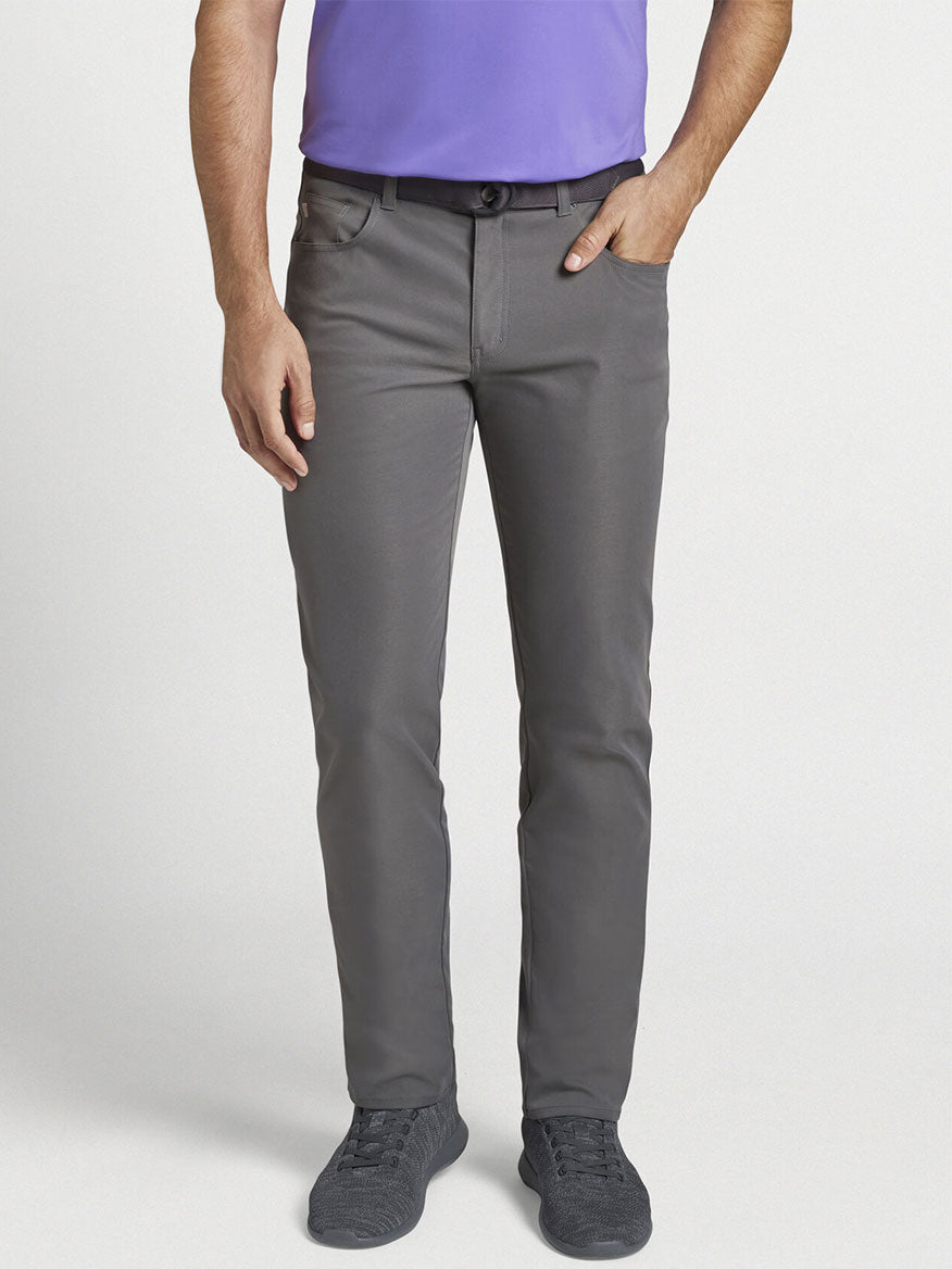 The man, a PGA Tour player, is wearing Peter Millar Performance Five-Pocket Pant in Iron and a purple shirt.