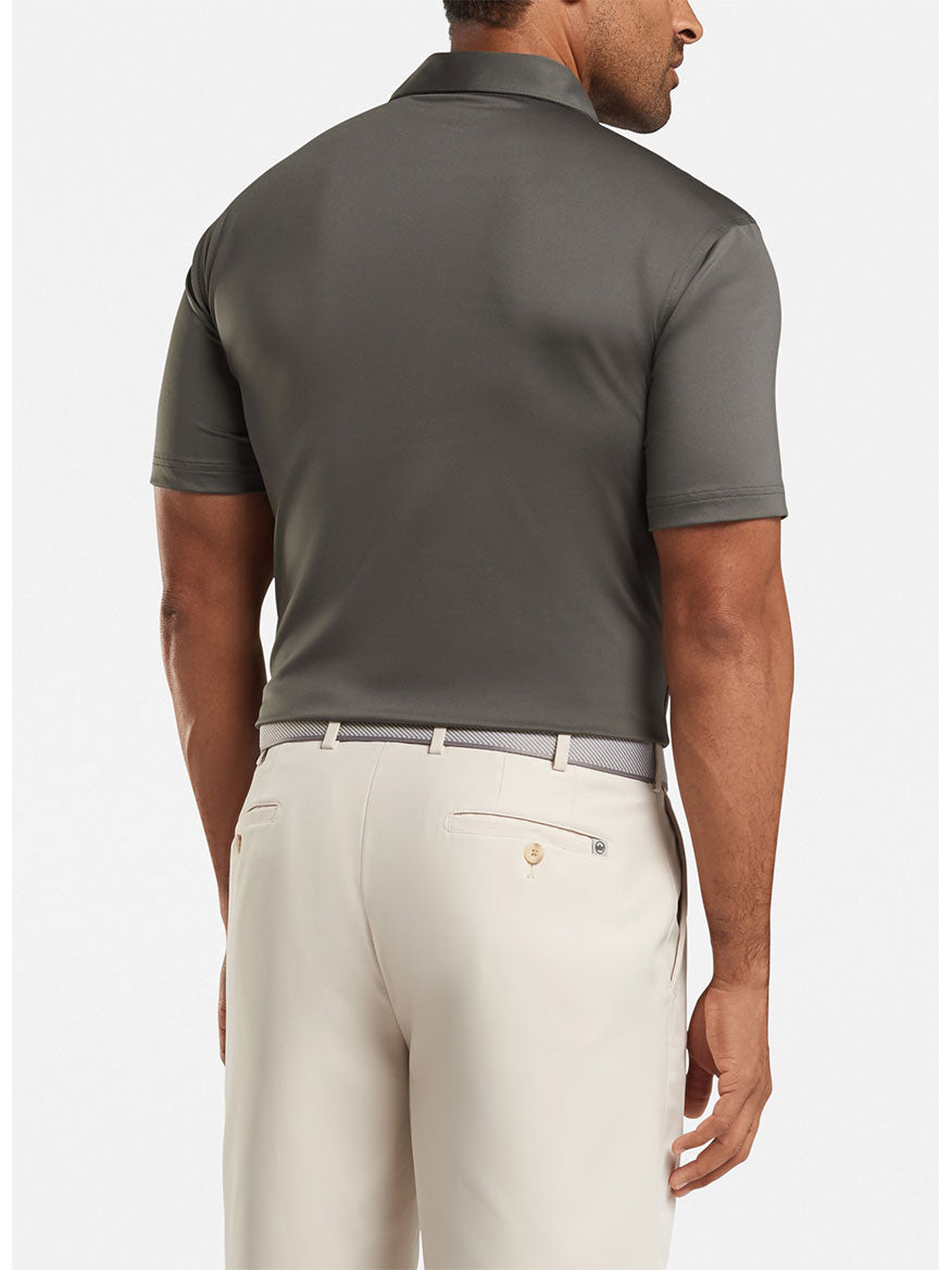 A man wearing the Peter Millar Solid Performance Jersey Polo in Iron with a Sean Self Collar and light beige pants, seen from the back.
