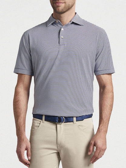Man wearing a Peter Millar Hales Performance Jersey Polo in Navy with UPF 50+ sun protection and khaki trousers.
