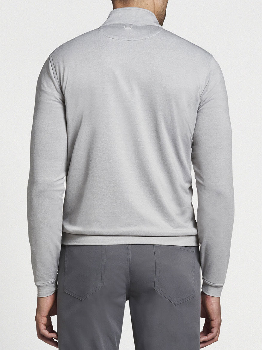 Man viewed from behind wearing a Peter Millar Perth Melange Performance Quarter-Zip in Gale Grey and gray pants.