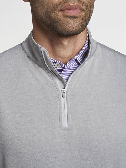 Man dressed in a Peter Millar Perth Melange Performance Quarter-Zip in Gale Grey over a purple striped shirt.