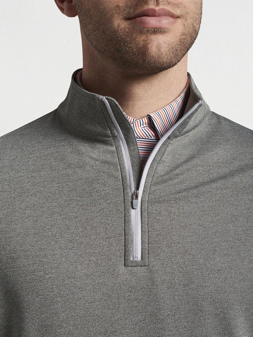 Close-up of a man's neck and chin showing a grey Peter Millar Perth Melange Performance Quarter-Zip in Smoke over a striped shirt.