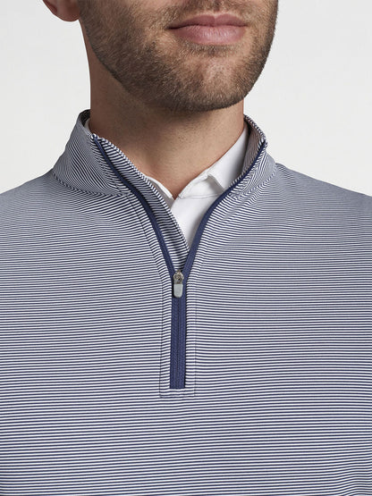 Man wearing a white-collar shirt under a striped Peter Millar Perth Sugar Stripe Performance Quarter-Zip in Navy/White with four-way stretch.