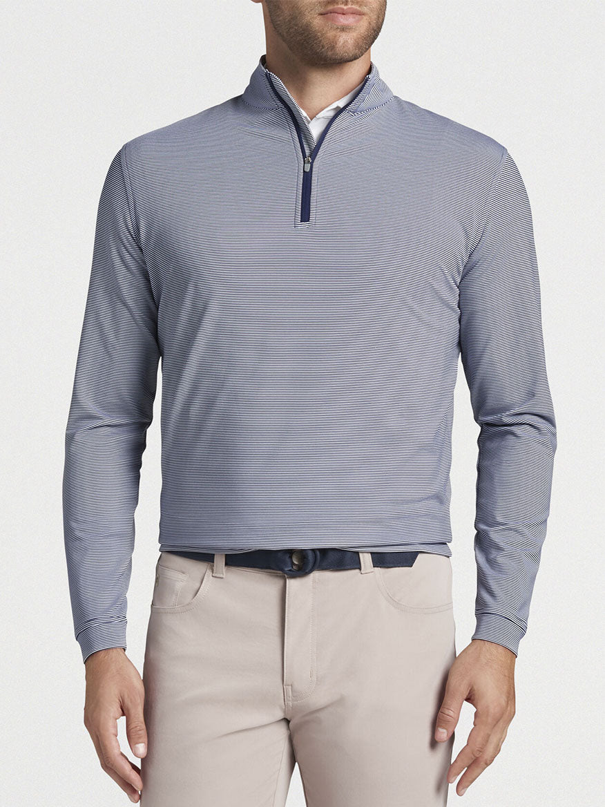 Man wearing a Peter Millar Perth Sugar Stripe Performance Quarter-Zip in Navy/White long-sleeve shirt and beige pants.