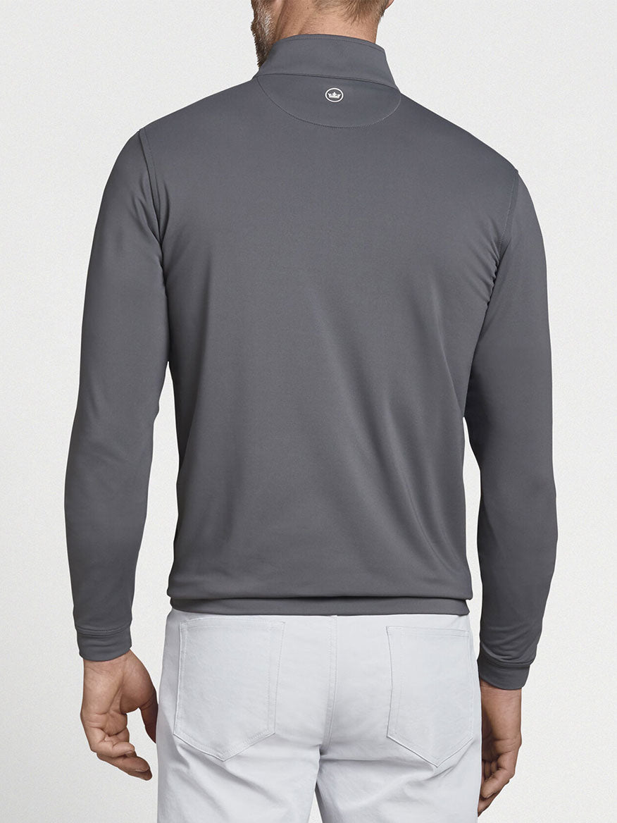 The back view of a man wearing a Peter Millar Perth Performance Quarter-Zip in Iron.