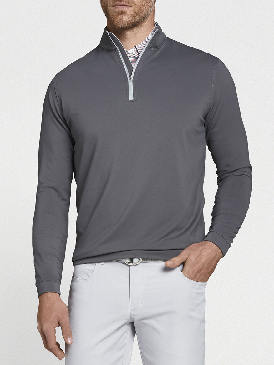A performance-focused man wearing a Peter Millar Perth Performance Quarter-Zip in Iron.