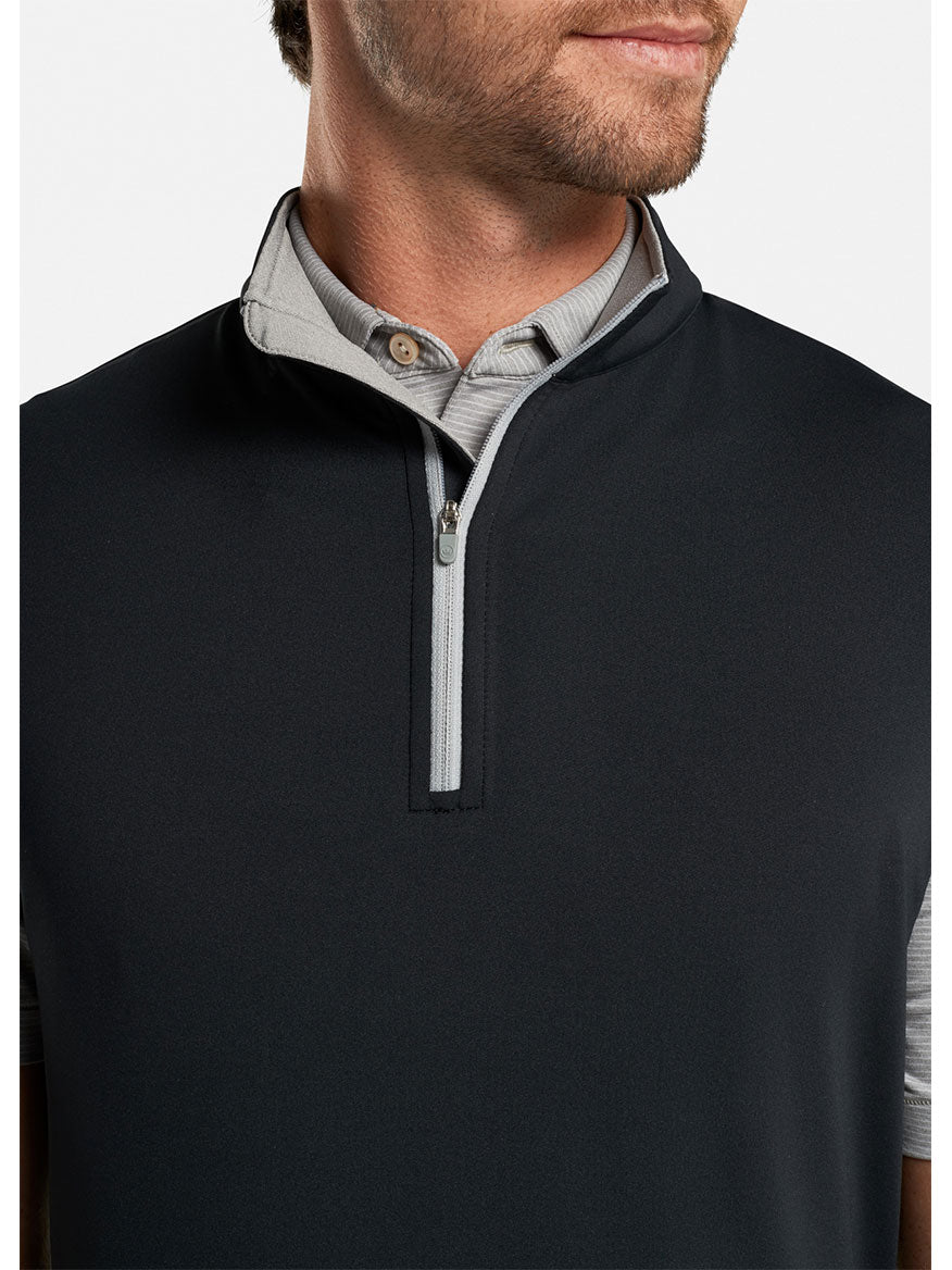 A man wearing a Peter Millar Galway Performance Quarter-Zip Vest in Black.