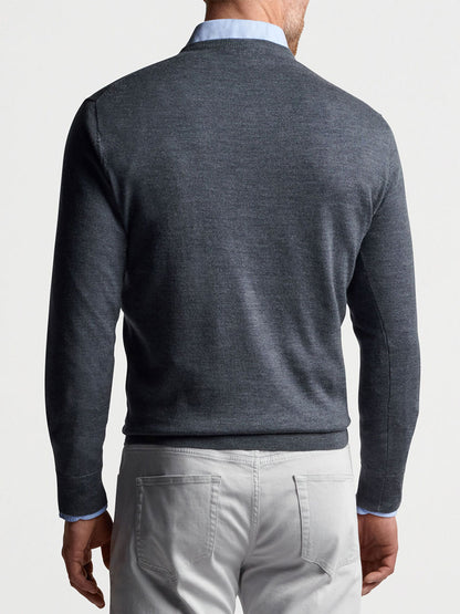 The back view of a man wearing a grey Peter Millar Autumn Crest V-Neck in Charcoal sweater and white pants.