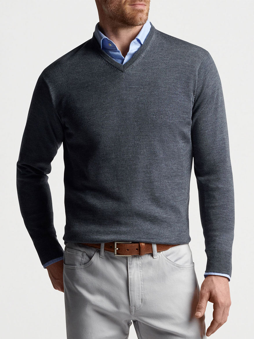 Peter Millar Autumn Crest V-Neck in Charcoal, a man wearing a v-neck sweater made of Merino wool, complemented by gray pants.