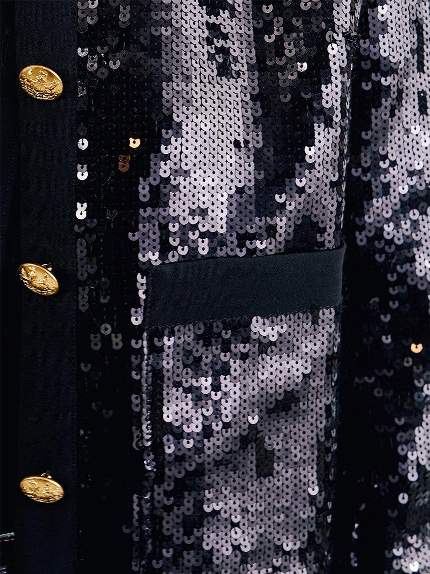 Close-up of the Nili Lotan Katherine Sequin Jacket in Black, showcasing a black sequin and crepe finish, complemented by embroidered gold buttons and a visible front pocket.