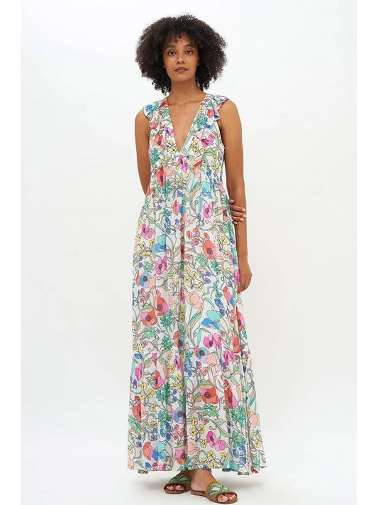 A woman stands facing the camera, wearing the Oliphant Ruffle V-Neck Maxi Dress in Zinnia Multi, paired with brown sandals, on a white background.
