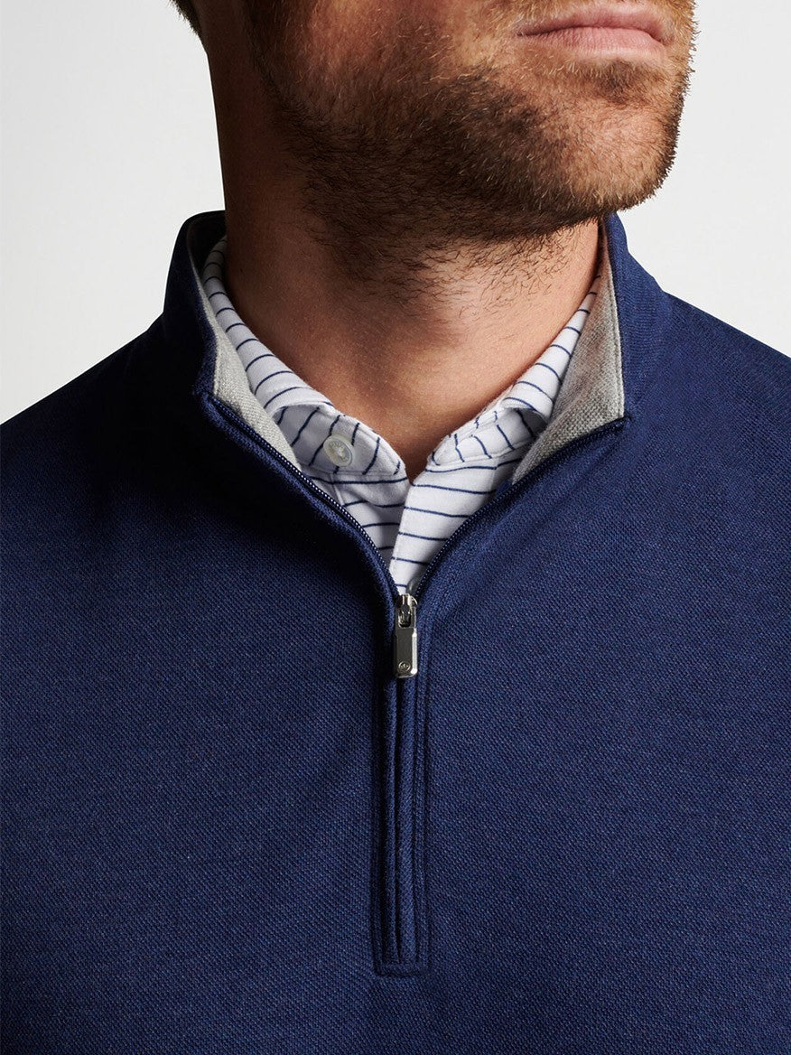 A man wearing a Peter Millar Crown Comfort Pullover in Navy with a striped shirt.