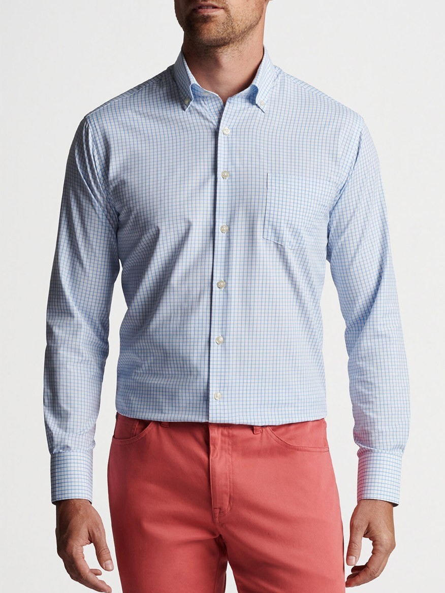 Man wearing a blue checkered Peter Millar Hanford Performance Twill Sport Shirt in Cottage Blue with red chino pants.