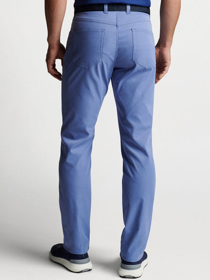 The Peter Millar eb66 Performance Five-Pocket Pant in Port Blue showcased the back view of a man donning blue pants.