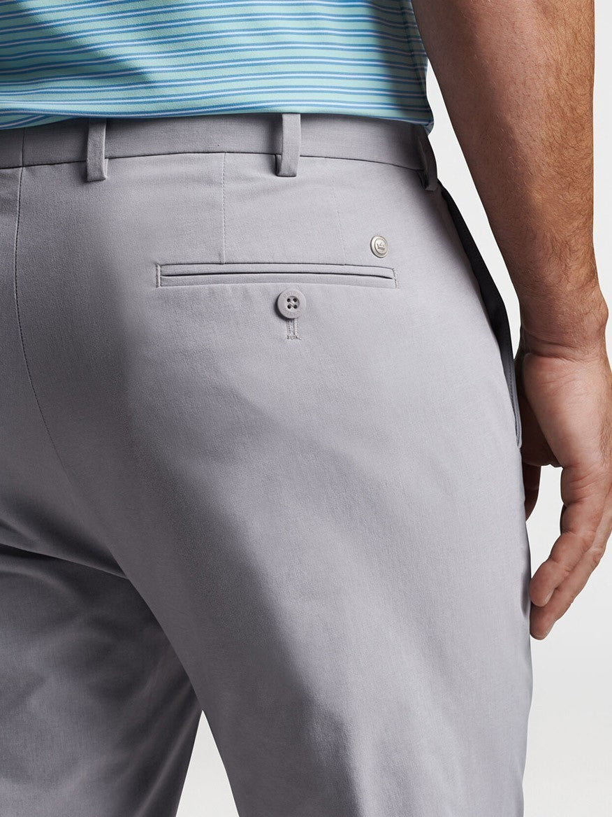 The back view of a man wearing Peter Millar Surge Performance Trouser in Gale Grey athletic apparel.