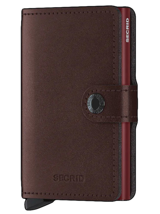 A brown leather Secrid Miniwallet Metallic in Moro with RFID protection, a card protector, and an elastic closure band.