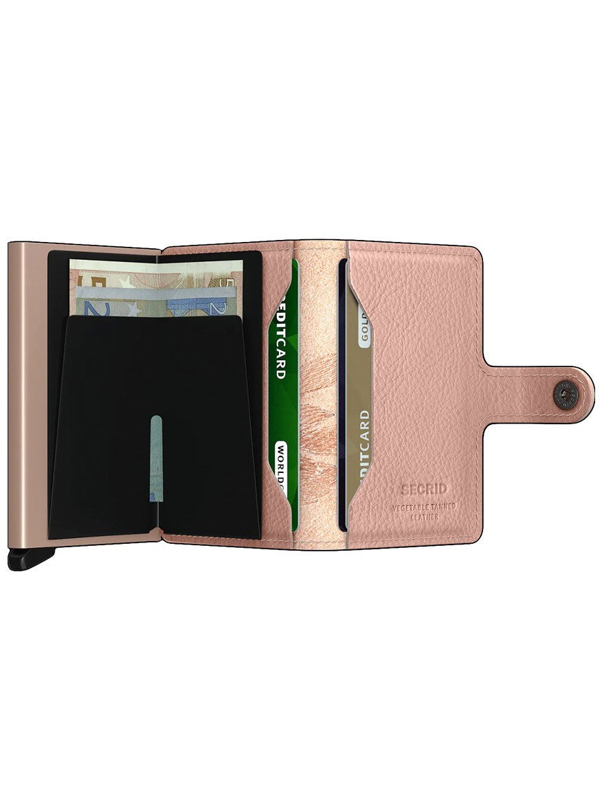 An open, metallic-pink Secrid Miniwallet Stitch in Magnolia Rose with RFID protection, cards, and cash.