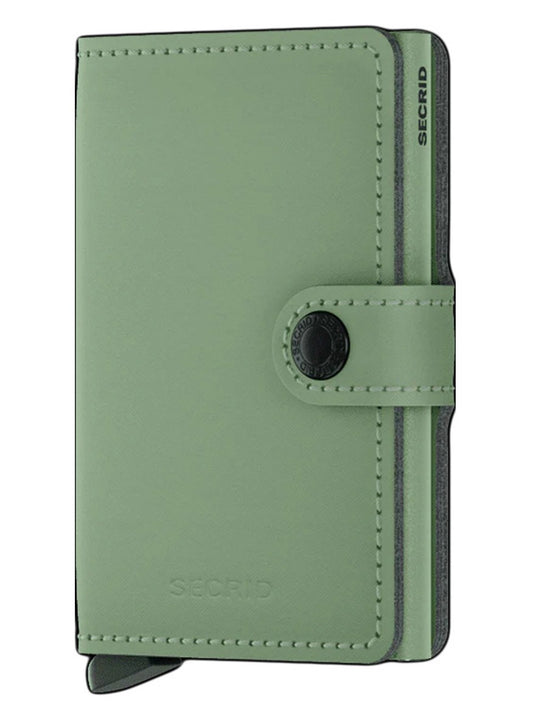 Green leather Secrid Miniwallet Yard Powder in Pistachio with a button closure, card slider, and RFID protection.