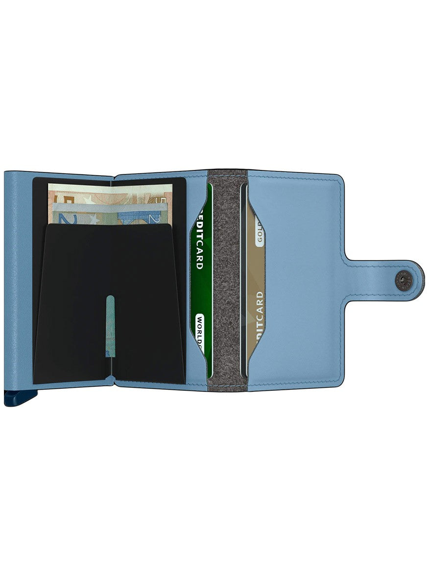 A Secrid Miniwallet Yard Powder in Sky Blue with RFID protection, open flat showing cash and card compartments with cards and bills inside.