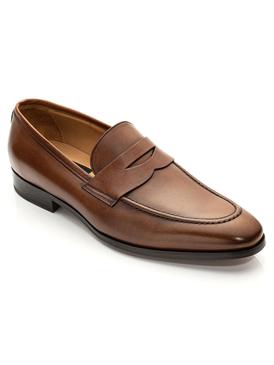 A single To Boot New York Tesoro loafer in Brandy, featuring premium leather with a low heel and a penny strap across the upper, crafted by Italian artisans using fine calf hides, is displayed against a white background.