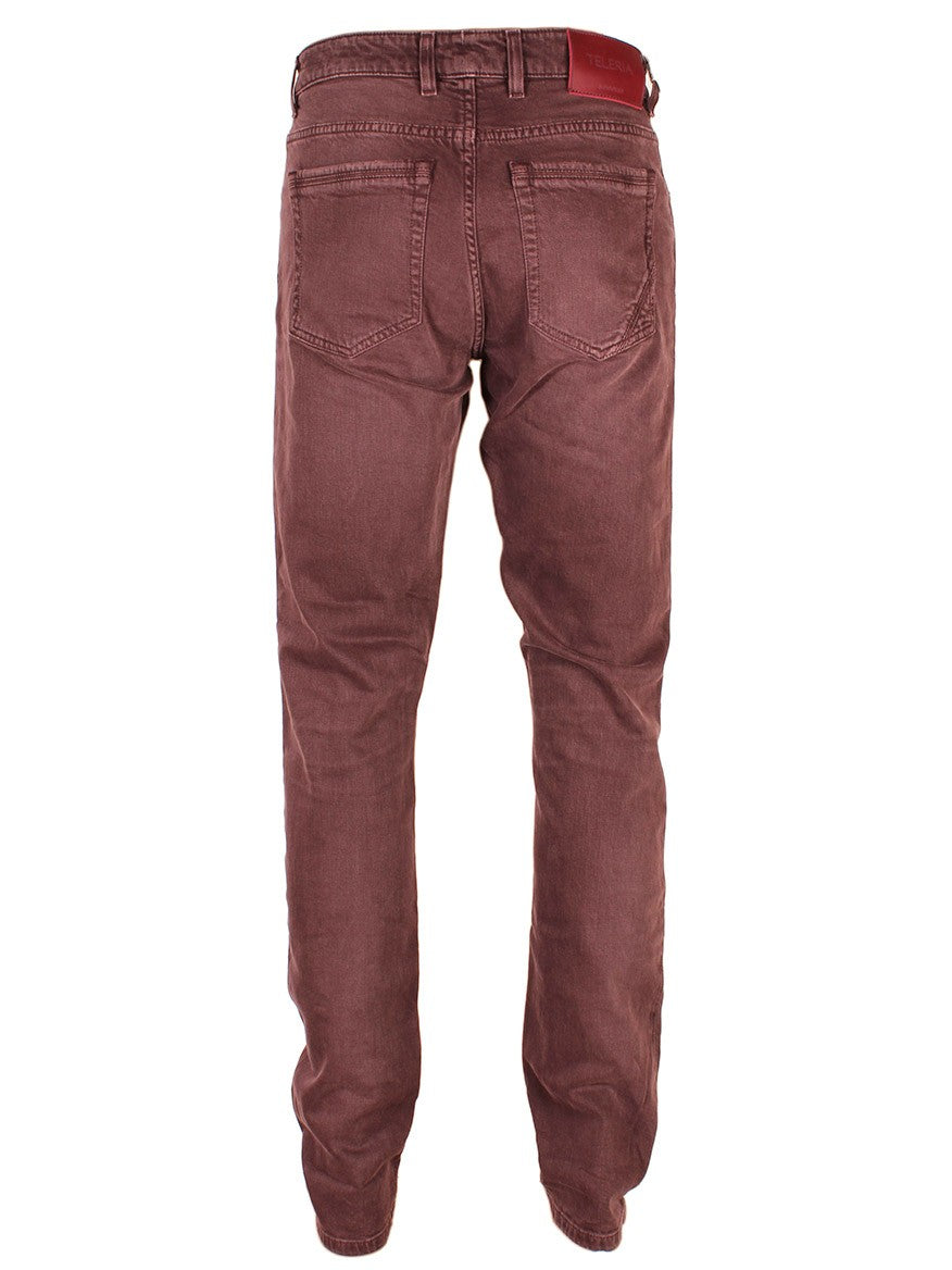 Pair of Teleria Zed Cobra Selvedge Stretch Denim in Mosto trousers isolated on a white background.