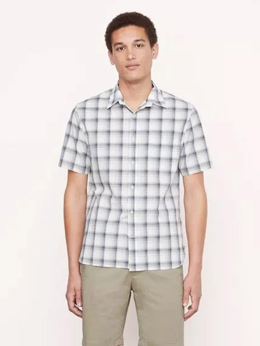 A person wearing a Vince Atwater Plaid Short Sleeve Shirt in Celery and khaki pants stands in front of a plain background.