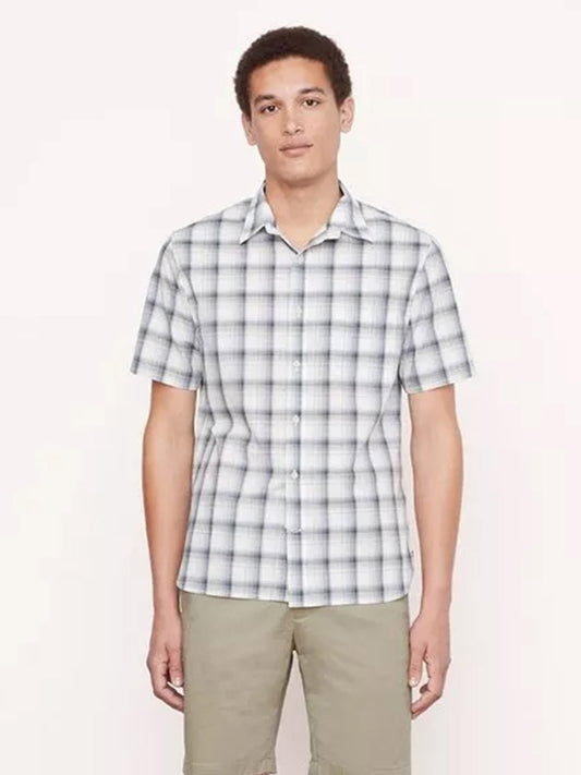 A person wearing a Vince Atwater Plaid Short Sleeve Shirt in Celery and khaki pants stands in front of a plain background.