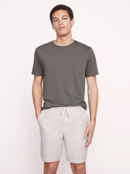 Man standing in casual gray t-shirt and breathable fabric, Vince Lightweight Hemp Short in Beach Sand with drawstring closure.