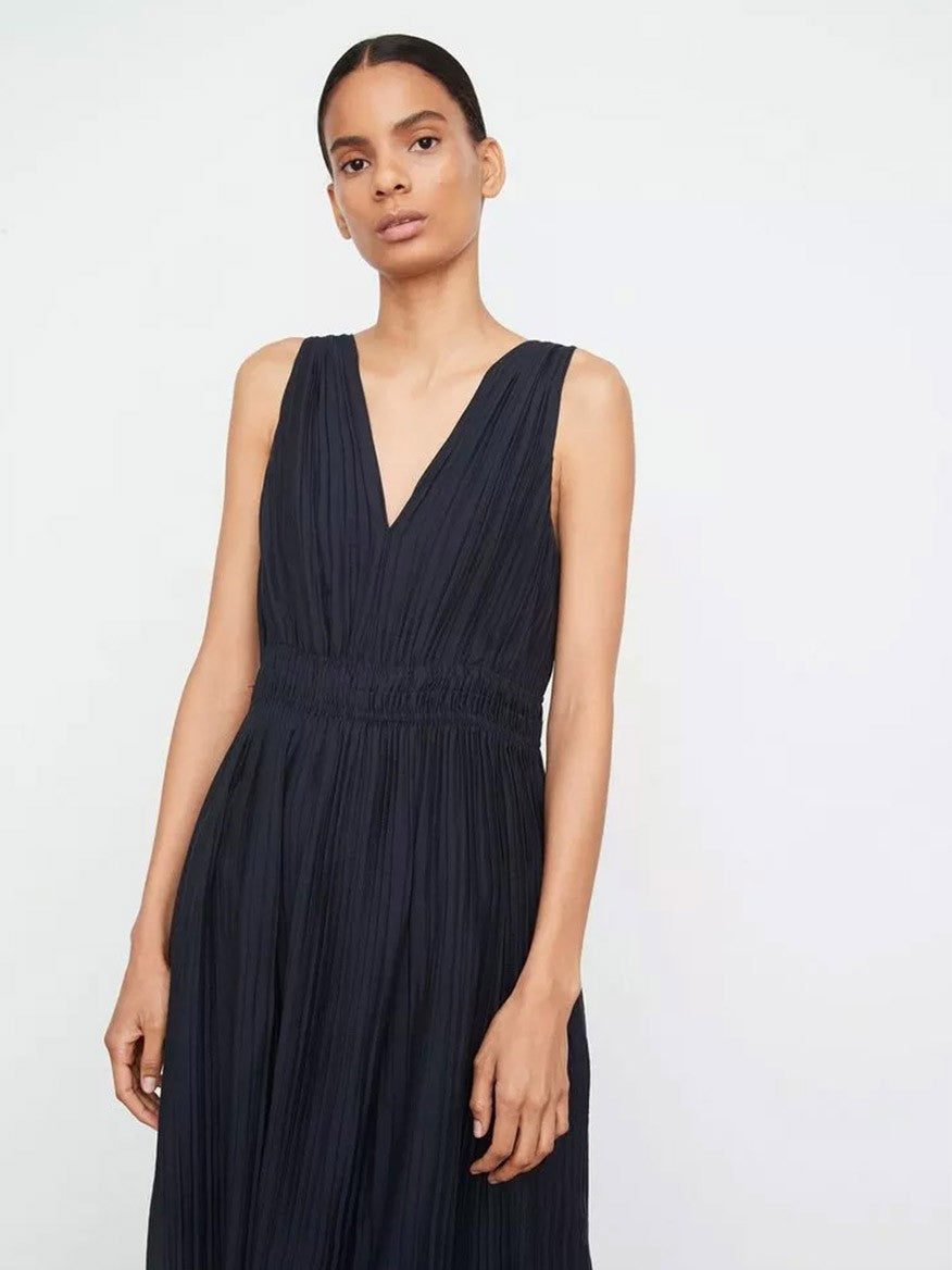 The model is wearing a Vince Pleated Double V-Neck Dress in Coastal.