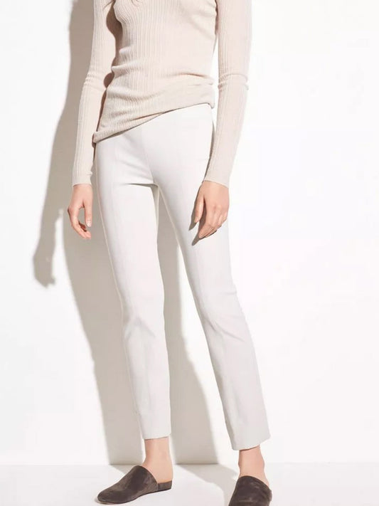 Woman in a light-colored sweater and Vince Stitch Front Seam Ponte Legging in Gesso with brown slip-on shoes standing against a white background.