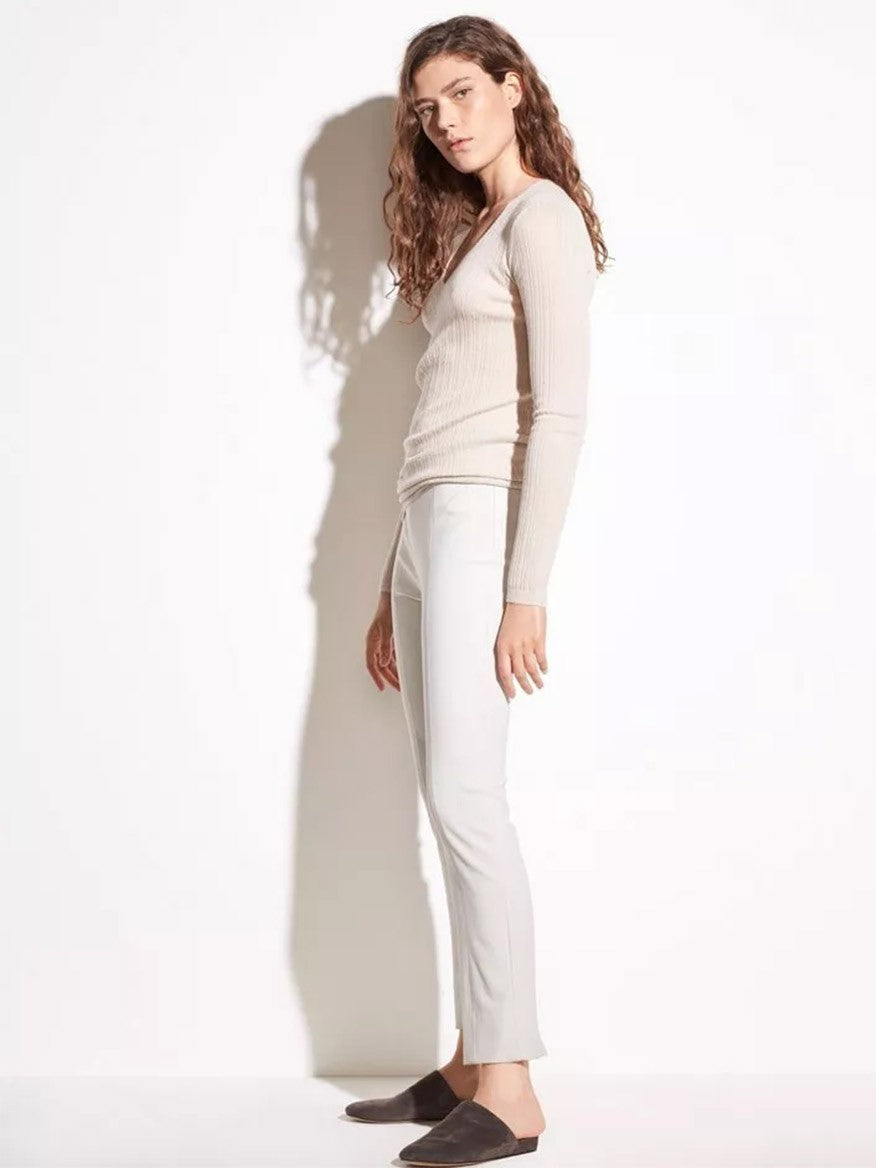 Woman in a light beige Vince Stitch Front Seam Ponte Legging in Gesso outfit posing against a white background.