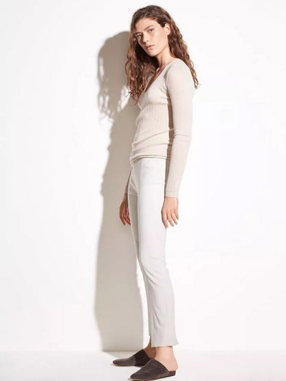 Woman in a light beige Vince Stitch Front Seam Ponte Legging in Gesso outfit posing against a white background.