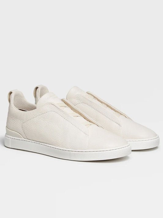 A pair of Zegna Off White Deerskin Triple Stitch™ sneakers crafted from deerskin with textured fabric and white soles, displayed against a light background.