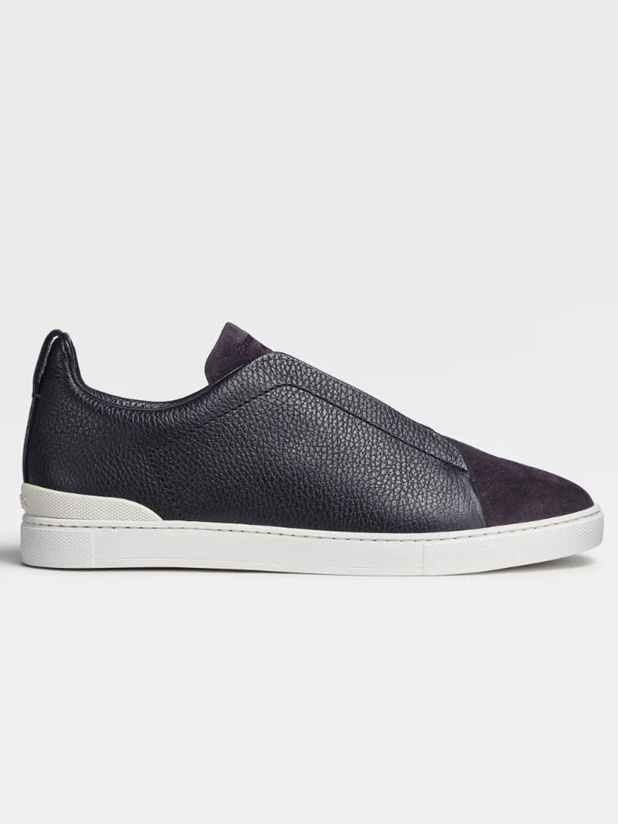 A single navy blue Zegna leather and suede Triple Stitch™ sneaker with a white sole and suede toe cap displayed against a neutral background.