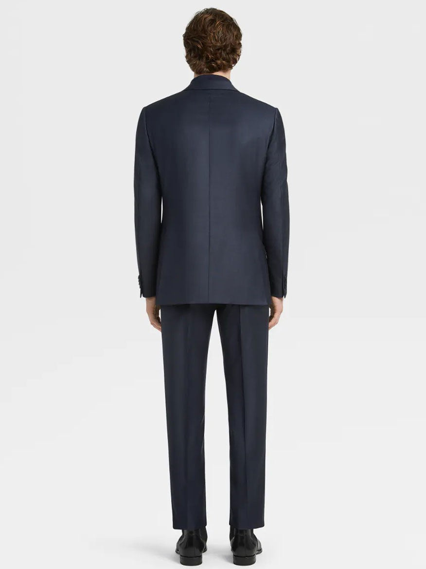 A man standing with his back to the camera, dressed in a Zegna Navy Blue Milano Trofeo™ Wool Suit in Pinpoint Pattern.