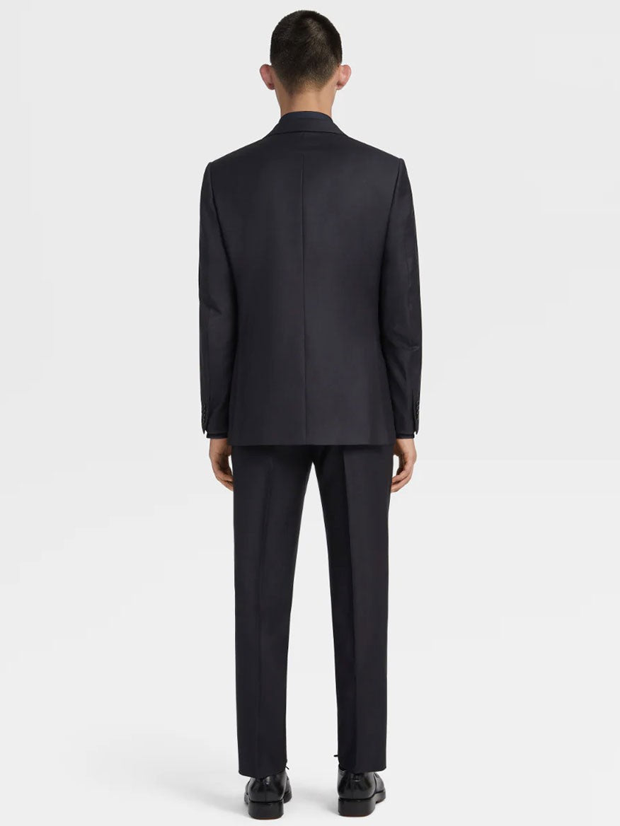 A person wearing a Zegna Navy Blue Milano Trofeo™ Wool Suit stands facing away from the camera against a plain white background.
