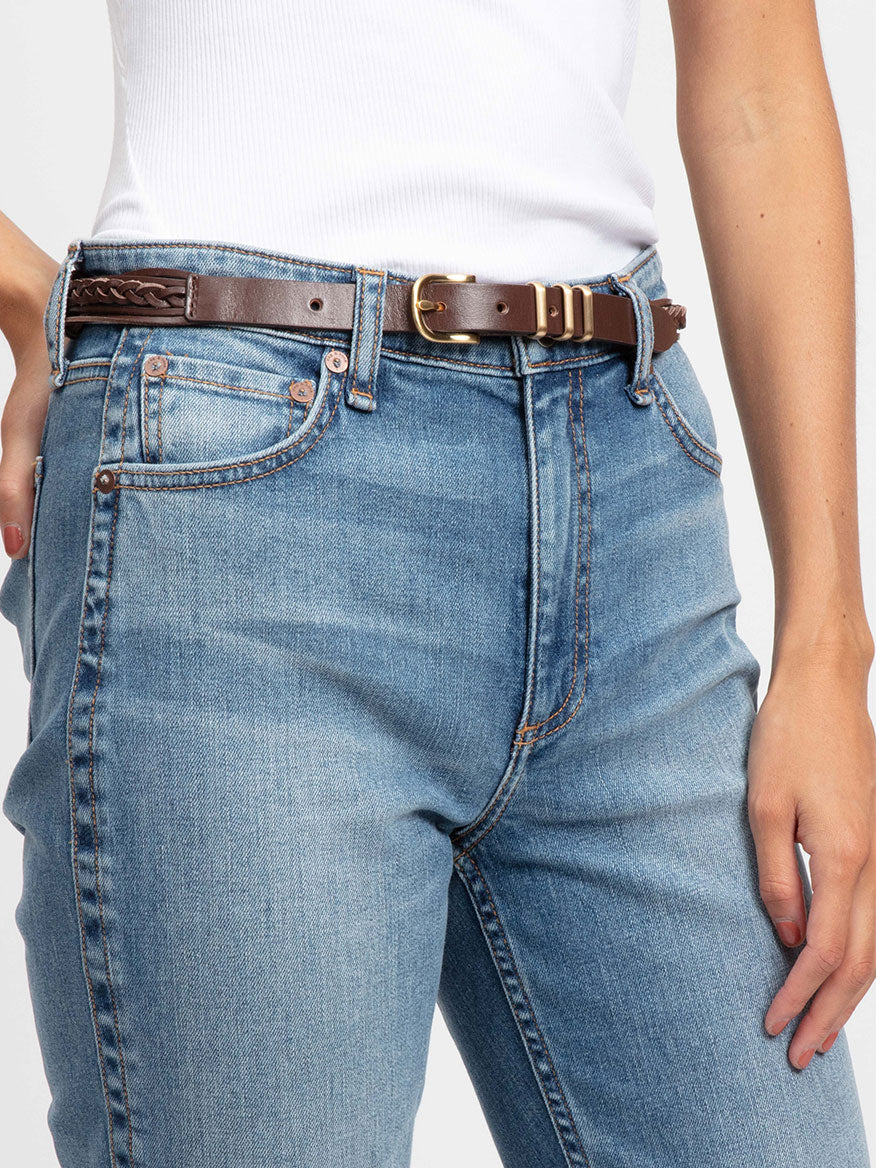 A woman wearing jeans with a rag & bone Knotted Jet Belt in Redwood.
