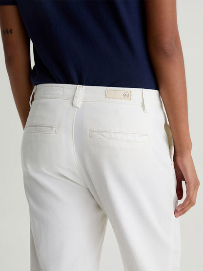 A person is shown from the back wearing AG Jeans Caden Straight Leg Trouser in Powder and a navy shirt, with one arm resting by their side.