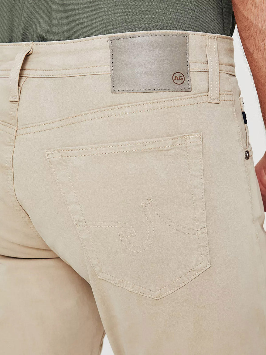The back view of a man wearing AG Jeans Everett in Desert Stone.