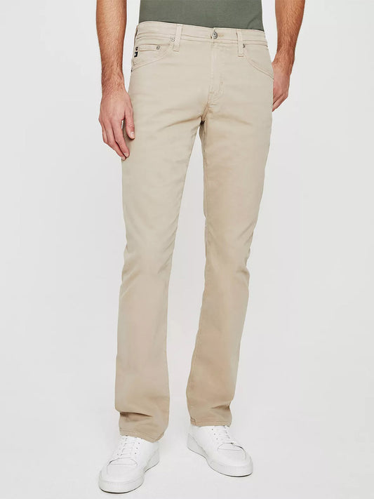 A comfortable man wearing AG Jeans Everett in Desert Stone pants.