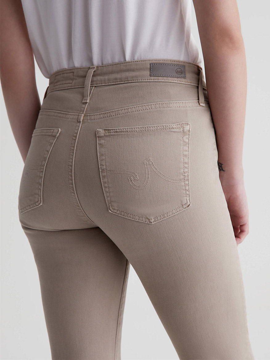 Close-up of the back of AG Jeans Farrah Boot Crop in Sulfur Desert Taupe worn by a person, highlighting the pocket design and waistband detailing.