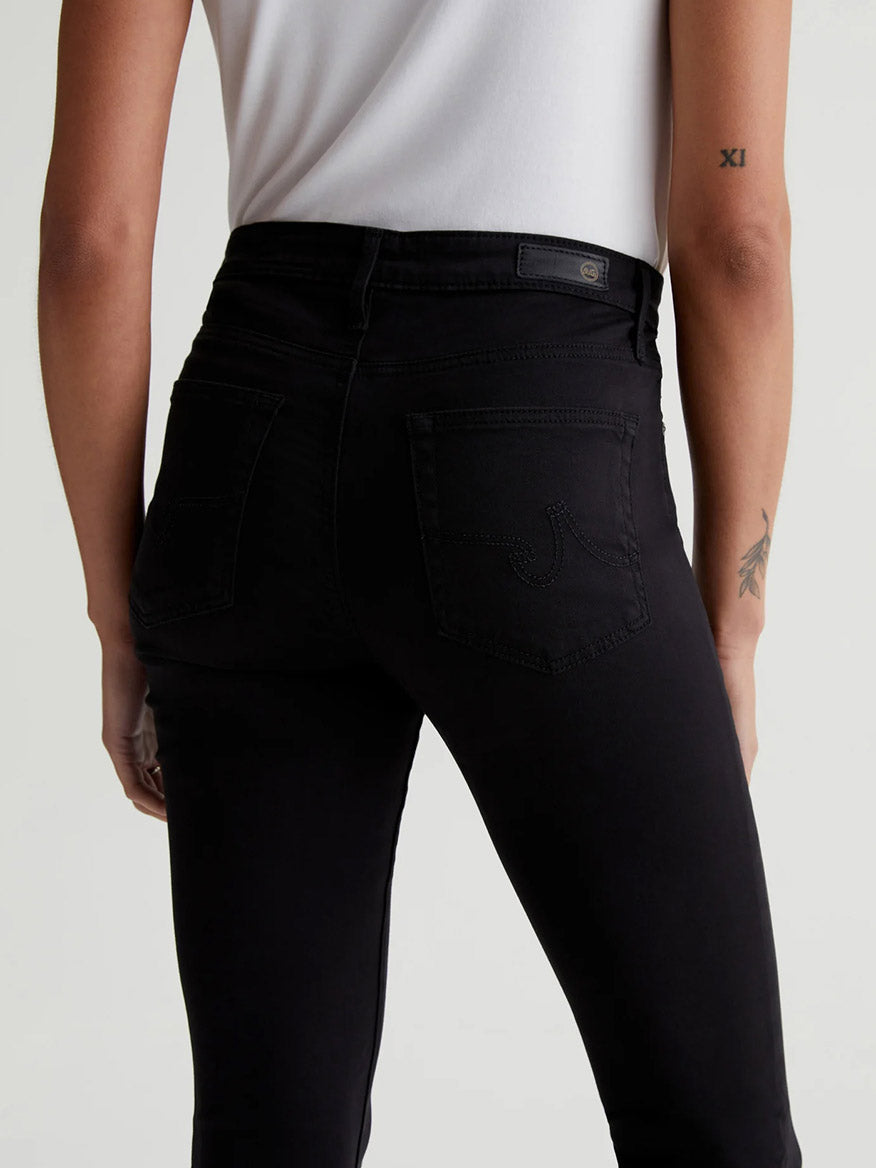 The back view of a woman wearing AG Jeans Prima Cigarette Leg in Super Black.