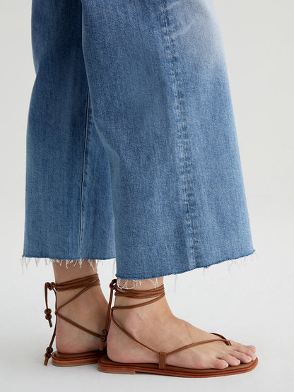 Person wearing AG Jeans Saige Wide Leg Crop in 22 Years Palma and brown strappy sandals.