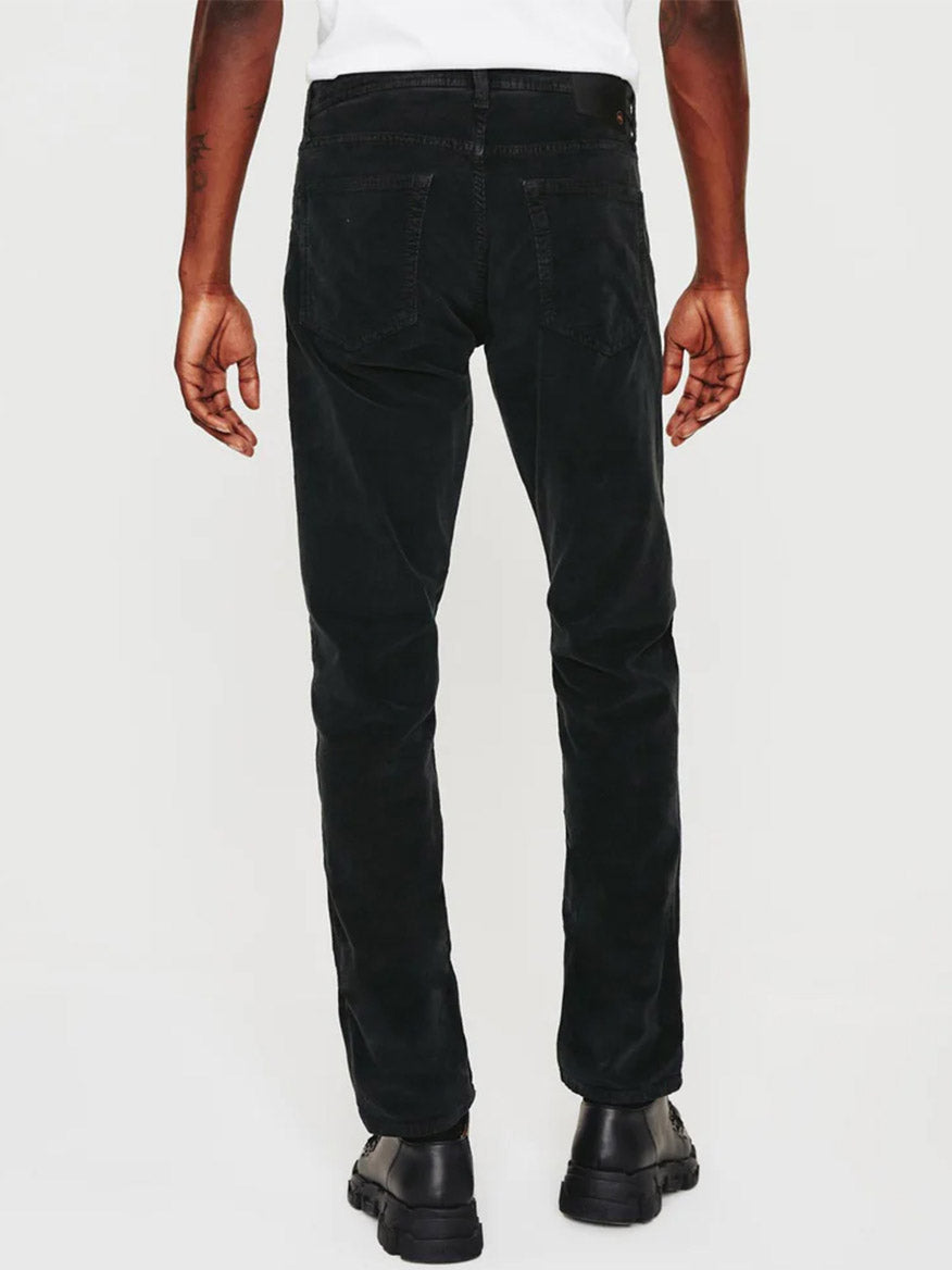A man wearing AG Jeans Tellis Corduroy Slim Fit in Sulfur Gunpowder pants.