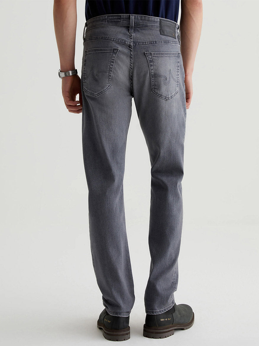 A person wearing AG Jeans Tellis in Prestige and black shoes is shown from the back against a plain background.