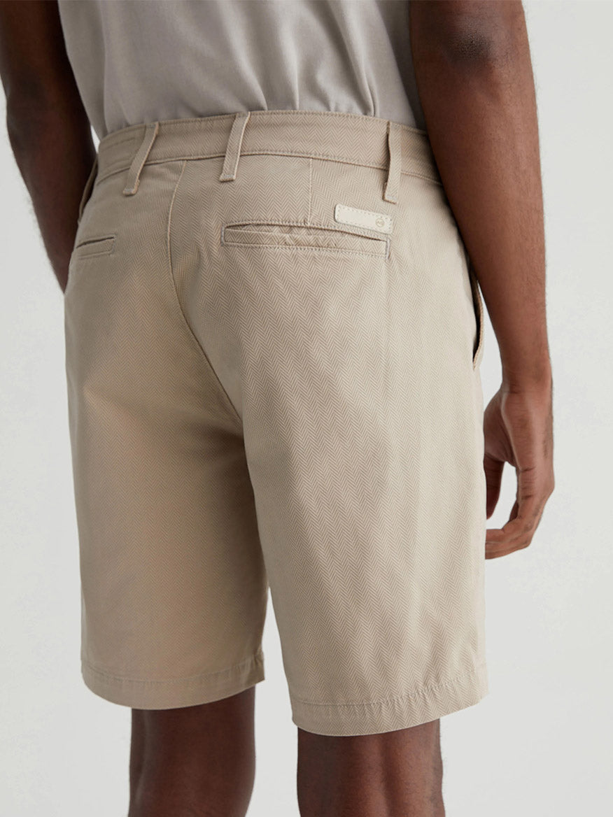 Rear view of a man wearing AG Jeans Wanderer Short in Parquet Khaki Multi with a focus on the shorts' fabric texture and pocket details.